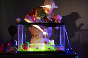 High Water performance man reaching into glass tank