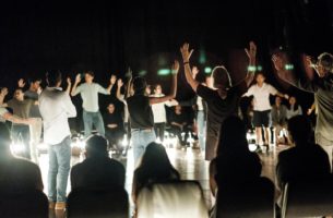 The Fever performance people standing with arms raised